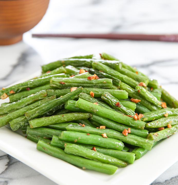 photo of chinese-style garlic green beans on a white plate