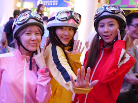 three young women wearing racing clothes, helmets, and goggles in Macau