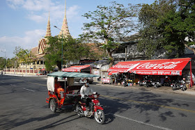 ma driving a tuk-tuk past the Cambodian Supreme Court building in Phnom Penh