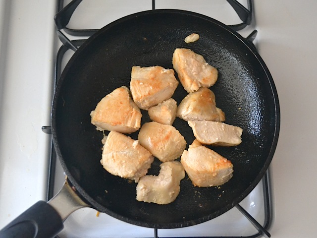 chicken cut into small chunks and cooking in skillet on stovetop