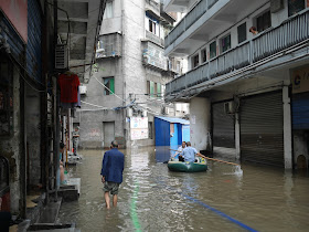 chengguan rowing a raft in a flooded street in Hunan