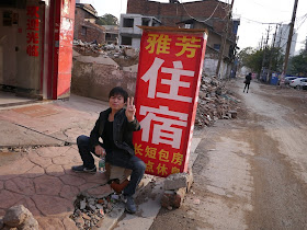man sitting in front of a motel sign at Beizheng Street in Changsha