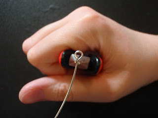 Grip the wire under the eye with chain nose pliers and bend the wire slightly