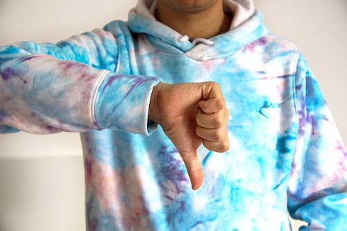 Free A Person in Tie Dye Sweater Doing Thumbs Down Stock Photo