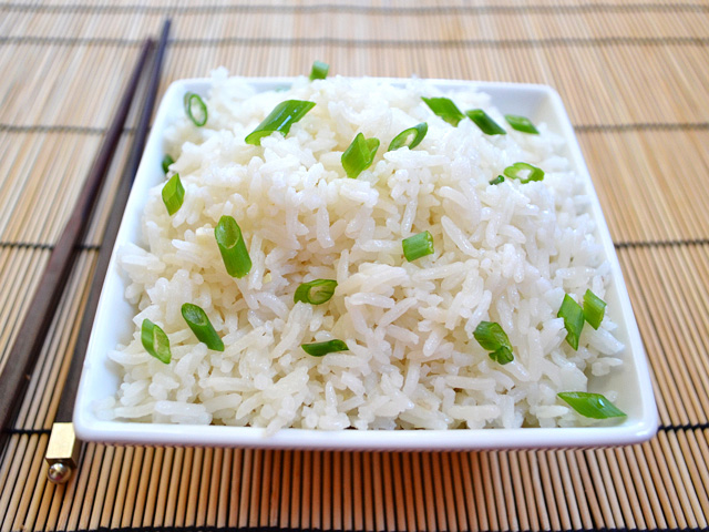 top view of a bowl of coconut rice with chopsticks on the side 