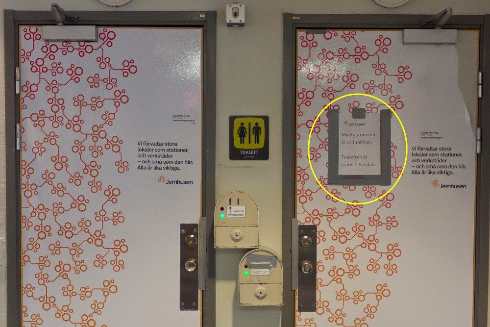 Text på skylten på den högra toaletten:: Myntautomaten ur funktion.  Toaletten är gratis tills vidare.