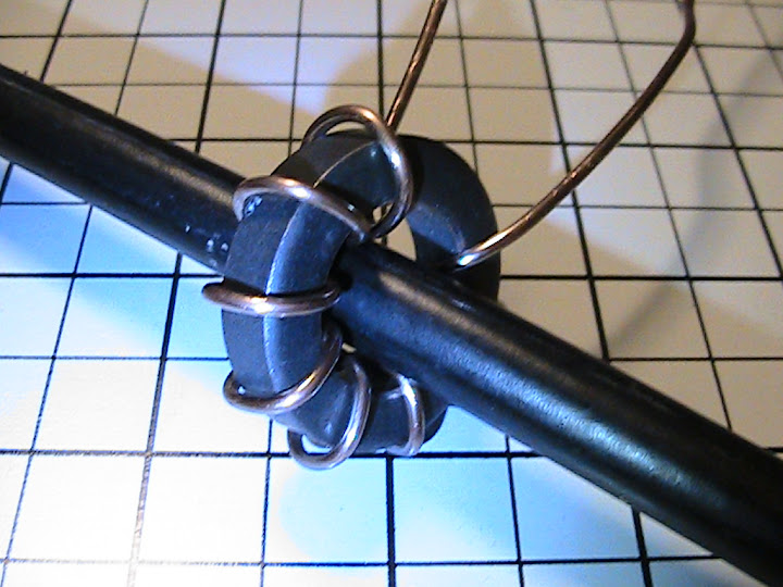 A
                      wide-spaced 10-turn coil of 14 AWG solid copper
                      wire was wound on an FT114-43 or FT140-43 ferrite toroid core
                      threaded over the loop wire (a 112 inch length of
                      RG-8A/U coaxial cable terminated in PL-259
                      connectors). Taps would later be soldered on the
                      6th and 8th turns after mounting in the coupling
                      enclosure. Spreading the coil turns
                      over the full circumference of the core distributes the
                      magnetic field and thermal losses throughout the core, 
                      raising the effective core saturation threshold, 
                      improving coupling efficiency, antenna Q and radiated field
                      strength.  The larger diameter FT140-43 core provides equally 
                      tight coupling to the loop, greater power capacity and
                      permits an easier fit over the loop.
