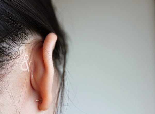 small music symbol tattoo behind ear