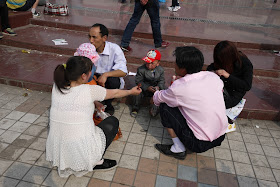 family sitting and squatting at Nanmen Square in Yinchuan, Ningxia, China