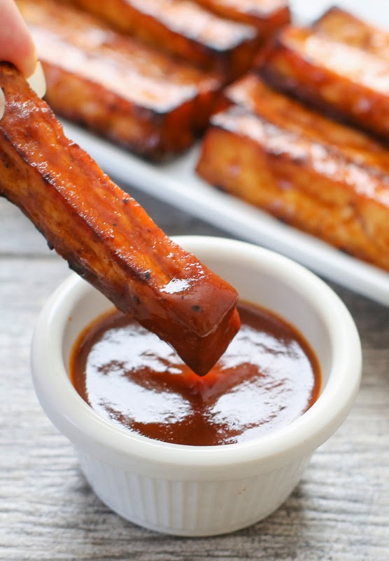 close-up photo of a bbq tofu fry being dipped in sauce