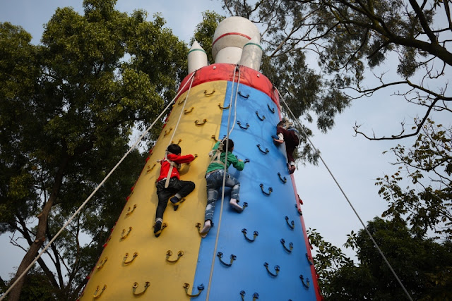 Three children climbing an inflatable climbing pylon at an amusement park ride in Zhuhai, China