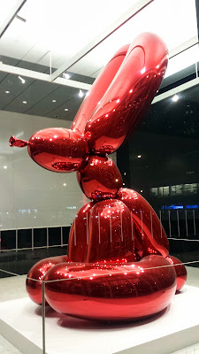 Red Rabbit by Jeff Koons, the father of shiny balloon dog sculptures (he does them in 5 Colors- Blue, Magenta, Yellow, Orange, Red) at 51 Astor Place.  It is a 4 feet tall, 6,600 pound mirror-polished stainless steel sculpture. There are four (Magenta, Blue, Yellow, Violet) others in the world