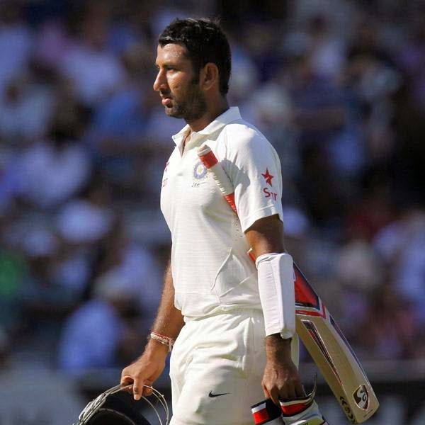 India's Cheteshwar Pujara walks back to the pavilion after getting out for 43 runs during play on the third day of the second cricket Test match between England and India at Lord's cricket ground in London on July 19, 2014.