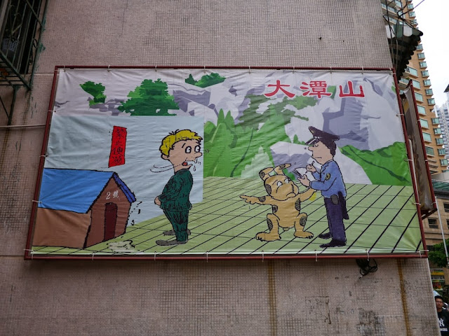 sign showing a dog pointing at a man urinating in front of its doghouse and a policeman writing a ticket