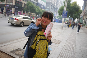 female college student handing out small advertisement fliers in Changsha, China