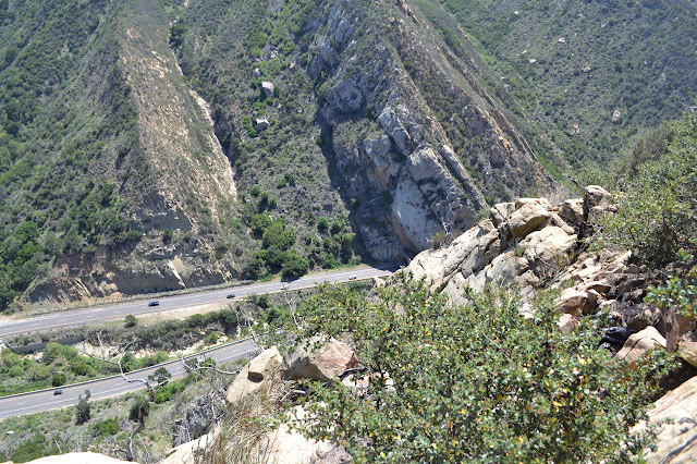 looking down along the edge of the ridge to the exit of the tunnel below