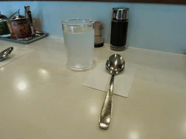 テーブルの上に置かれたスプーンとお冷