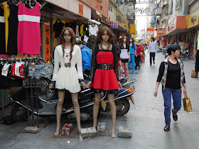 mannequins and woman walking by in Yangjiang, China