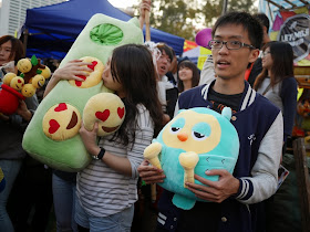two college students hold stuffed toys