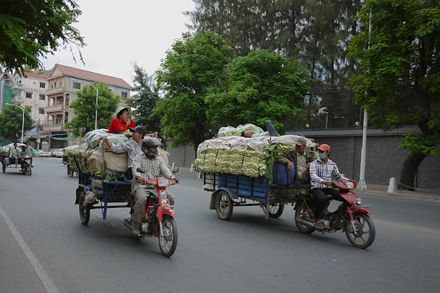 two motorbike pulling filled carts in Phnom Penh