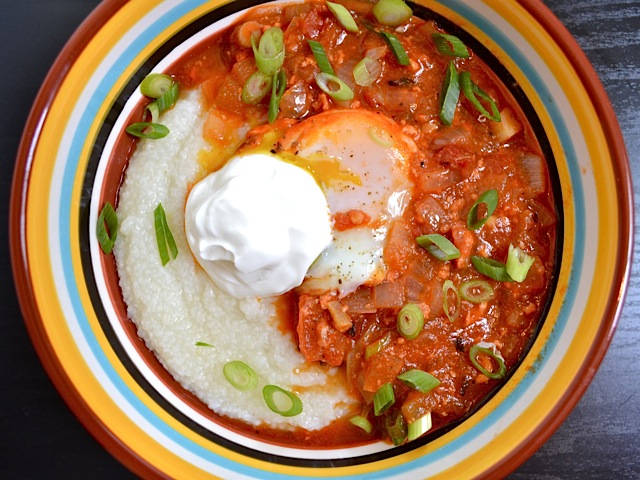 top view of salsa poached eggs with grits, topped with a dollop of sour cream