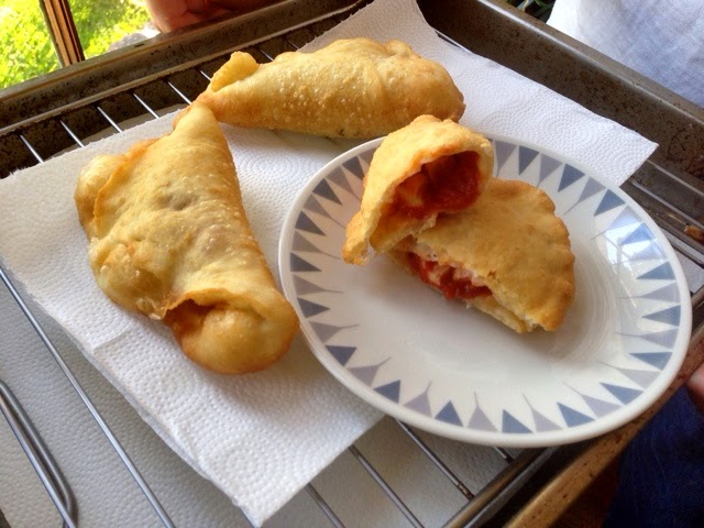 Deep-fried pizzas with mozzarella, tomatoes, and eggplants.