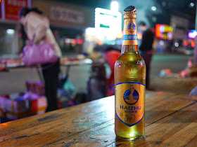 an opened bottle of Haizhu beer sitting on an outdoor table in Zhuhai