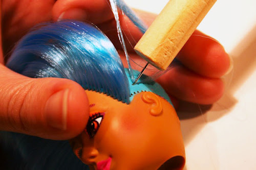 costurando cabelo de boneca utilizando ferramenta