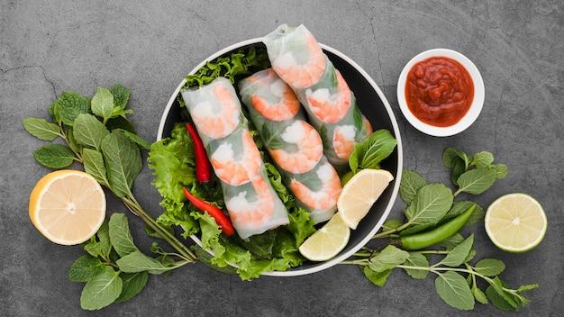 Free photo bowl of shrimp rolls with mint and lemon