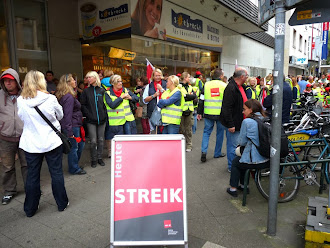 Vor dem Kaufhof, Kolleginnen und Kollegen mit Fahnen und Transparent: »Streik«.