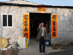 man standing in front of an open entrance to a one-floored building