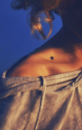 small star tattoo on collar bone of women