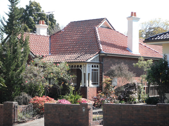 An ornate timber valance under the rafters of the verandah, with additional bracketing and timber ornamentation of the verandah posts