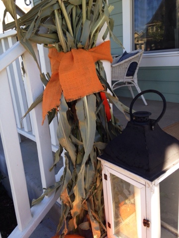 Fall porch with corn stalks and pumpkin topiaries