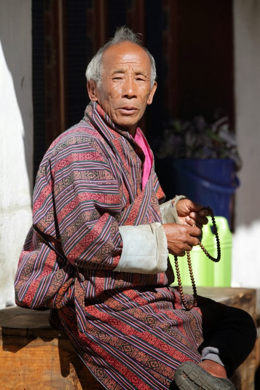 Old Bhutanese man in prayer at Trongsa, Bhutan