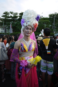 man dressed up in colorful women's clothing and wearing a large wig