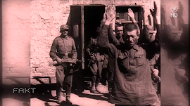 Sowjetische Kriegsgefangene mit erhobenen Händen, bewacht von Wehrmachtssoldaten.