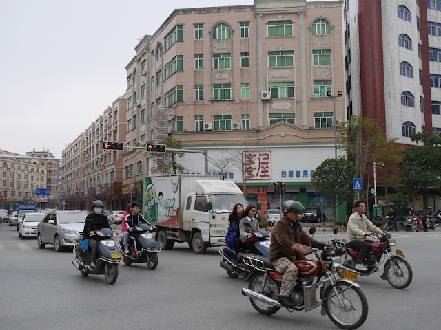 motorbikes and cars crossing an intersection in Yangjiang, China