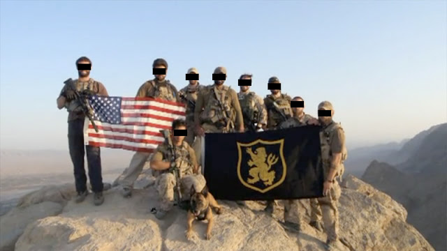 Gold Squadron operators posing with an American flag and squadron flag in Afghanistan
