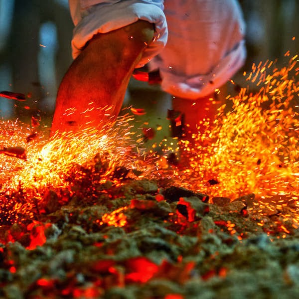 A devotee of "Chao Pho Kuan U Shrine" runs on burning charcoal as he performs a fire-walking ceremony during celebrations for the vegetarian festival in Phang Nga.
