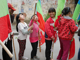 girls holding flags during the Nian Li Festival (年例节) in Maoming, China