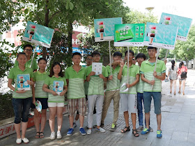 group of people wearing Oppo shirts and hold Oppo signs and other promotional material