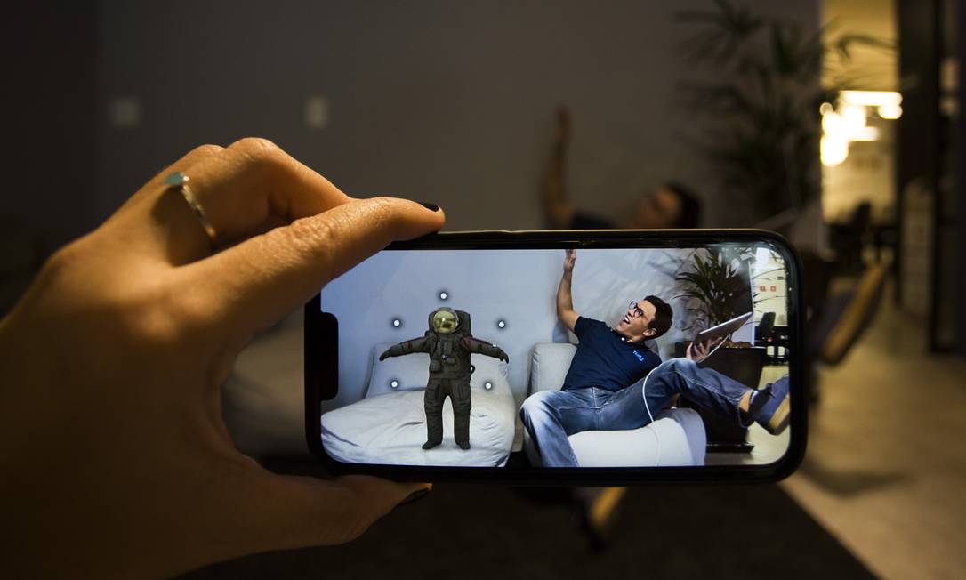 Simulação na tela - CEO da R2U, Caio Jahara, de 29 anos, testa solução de realidade aumentada que permite visualizar produtos como uma cadeira em uma sala Foto: Maria Isabel Oliveira / Agência O Globo