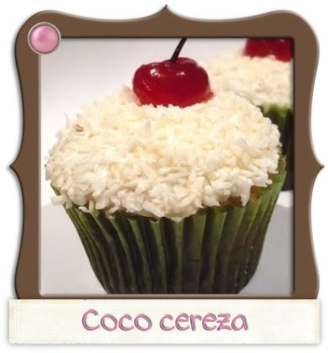 Cupcake de coco bañado con un delicioso icing de coco, cubierto con más coco y coronado con una cereza.