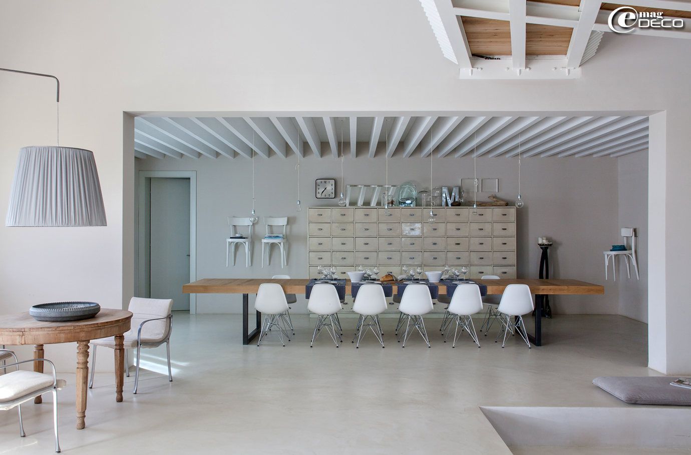 Dans la maison d'hôtes 'Malatesta' près de Pergola en Italie, une grande table avec plateau en chêne et piètement en métal entourée de chaises blanches 'DSR' de Charles et Ray Eames rééditées par 'Vitra'