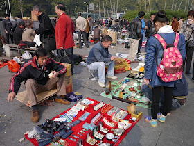 man peeling an egg at an outdoor antique market in Changsha, China
