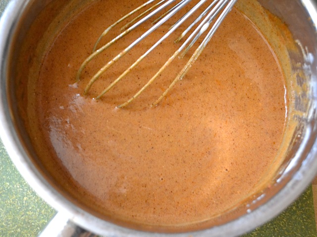 enchilada sauce being whisked in pot 