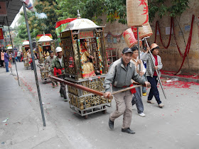 man pulling one of the gods for a Gods Parade in Maoming, China