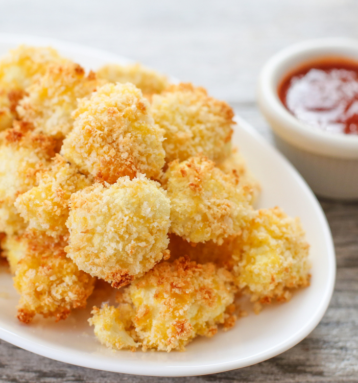 parmesan cauliflower bites on a white plate with dipping sauce