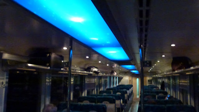 Ceiling of train lit up with galaxy images